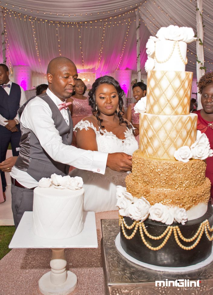 Luxury Wedding Photography The Groom and her Bride cutting cake at their wedding reception