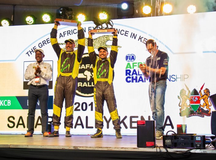 Baldev Chager and his navigator Ravi Soni celebrate their win of 2019 Safari Rally to the right is Oliver Ciesla - Managing Director - WRC Promoter GmbH and to the left is Phineas Kimathi the CEO of Safari Rally Project in Kenya.