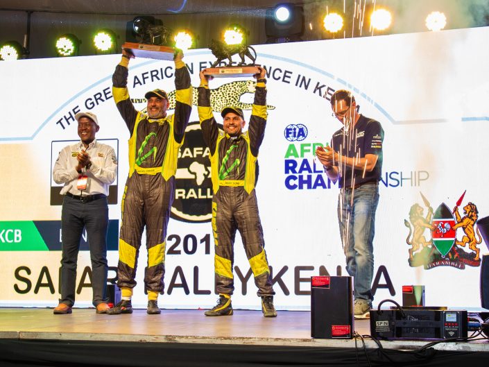 Baldev Chager and his navigator Ravi Soni celebrate their win of 2019 Safari Rally to the right is Oliver Ciesla - Managing Director - WRC Promoter GmbH and to the left is Phineas Kimathi the CEO of Safari Rally Project in Kenya.