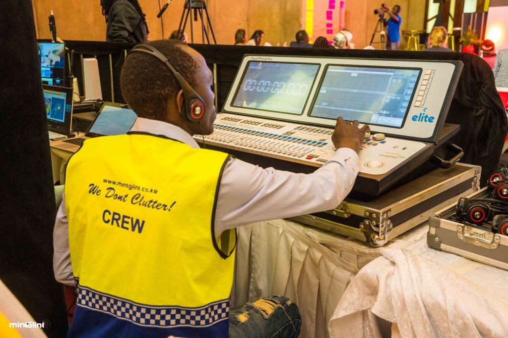Technician operating sound mixing console.