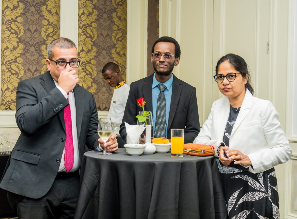 : Three professionals looking attentively toward a speaker during a JBQ Africa event, captured by Mintglint Media.