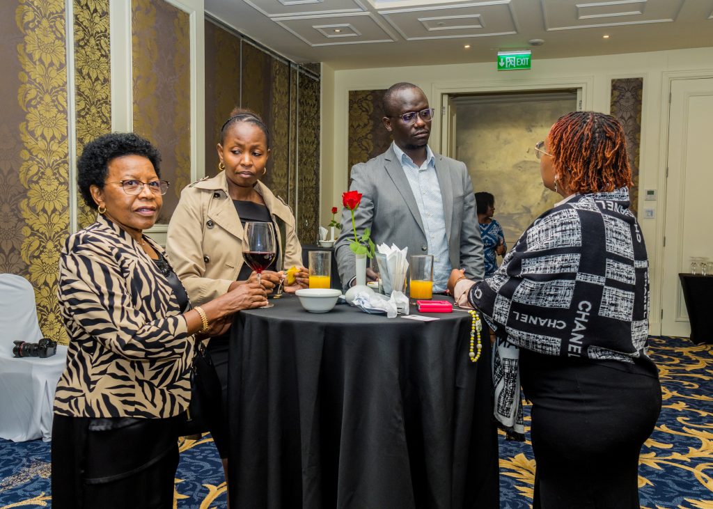 Four corporate professionals having a serious discussion around a high-top table at a JBQ Africa event in Kenya.